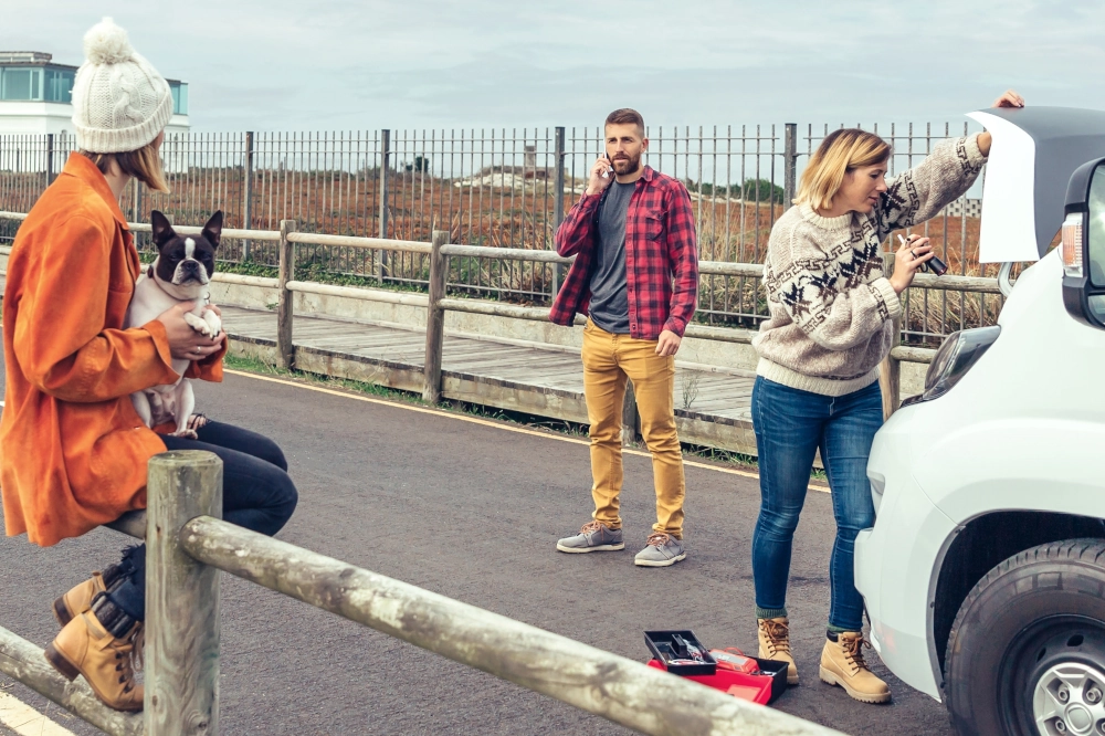 Photo of people at the roadside next to a car